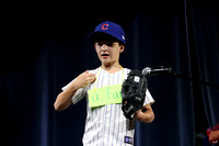 Boy dressed in a Chicago Cubs baseball uniform, word is "a fan."