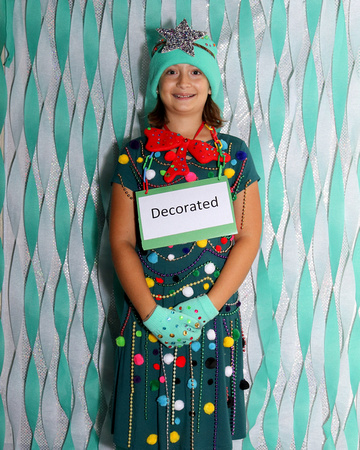 Girl dressed as a Christmas tree, word is Decorated