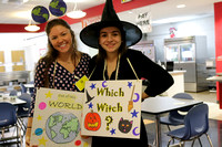 Two teachers, one dressed as the world, the other as a witch.