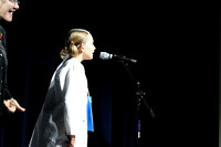 Girl dressed as doctor, speaks into the microphone.